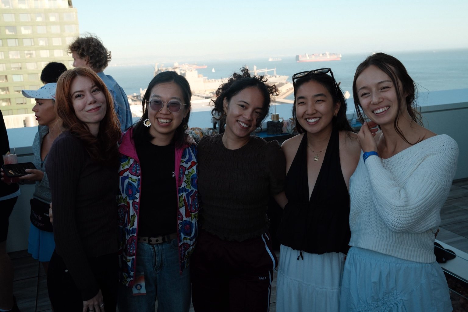 Community friends smiling together at a happy hour overlooking San Francisco Bay