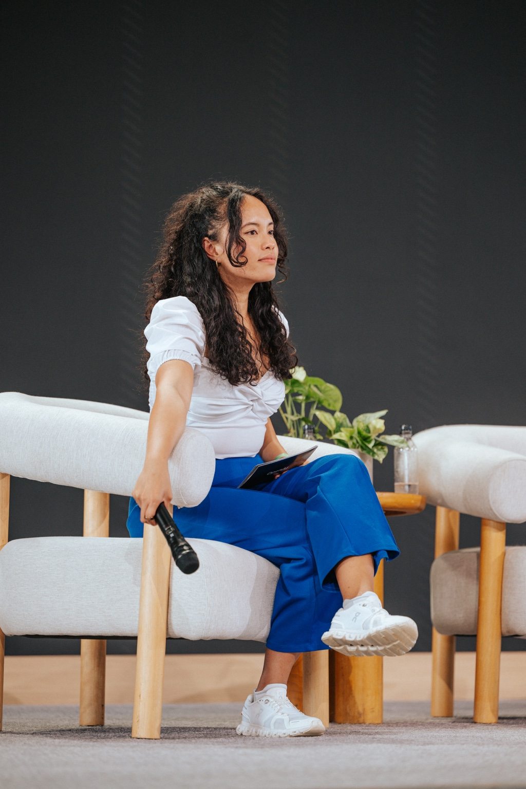 Pauline seated on the DevDay stage with a microphone and her question cards